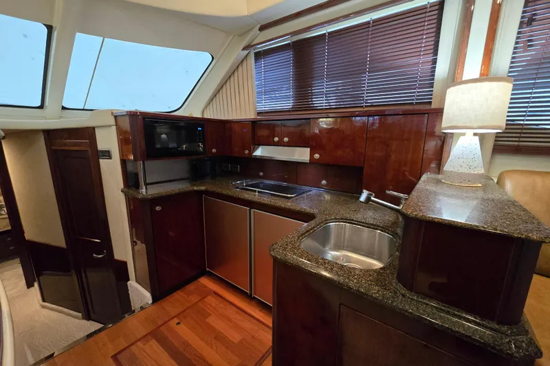 Slide: The Image of Luxurious interior of 2007 Sea Ray 52 Sedan Bridge yacht with modern kitchen and seating area. - 34