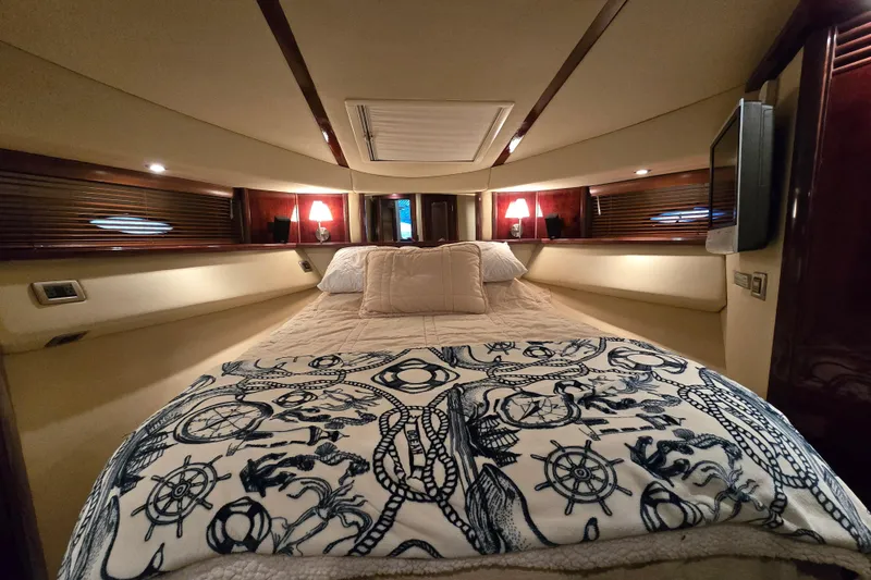 Slide: The Image of 2007 Sea Ray 52 Sedan Bridge cabin with wall-mounted TV and cozy bed. - 49