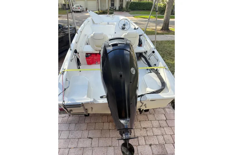 Slide: The Image of 2016 Boston Whaler 170 Super Sport boat with outboard motor on a brick driveway. - 11
