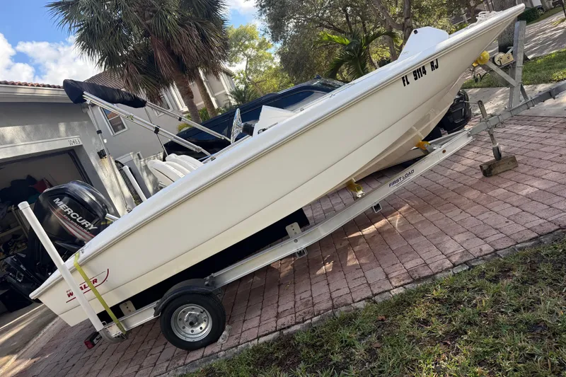 Slide: The Image of 2016 Boston Whaler 170 Super Sport boat on trailer, parked in driveway. - 12