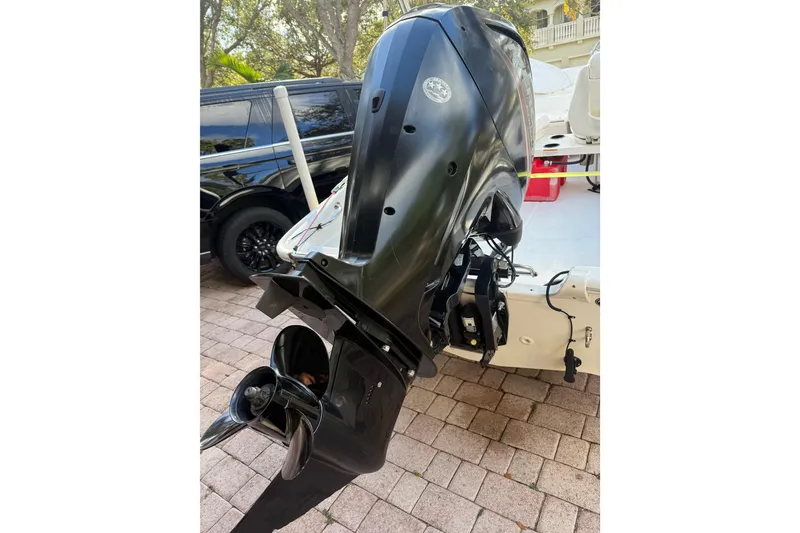Slide: The Image of 2016 Boston Whaler 170 Super Sport outboard motor on a paved driveway. - 13