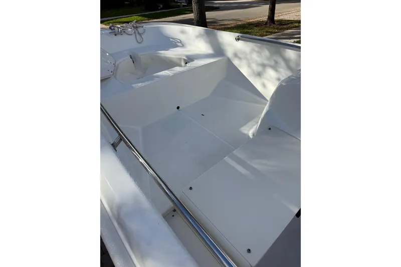 Slide: The Image of 2016 Boston Whaler 170 Super Sport boat interior with white seating and stainless steel railings. - 6