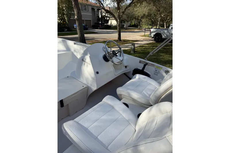 Slide: The Image of 2016 Boston Whaler 170 Super Sport interior with white seating and steering wheel. - 7