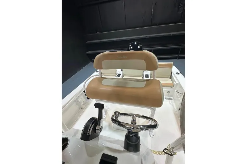 Slide: The Image of 2023 NauticStar 227 XTS boat interior with tan seating and steering wheel. - 5