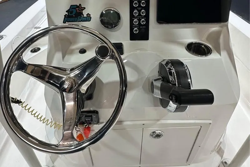 Slide: The Image of 2023 NauticStar 227 XTS boat console with steering wheel and controls. - 9