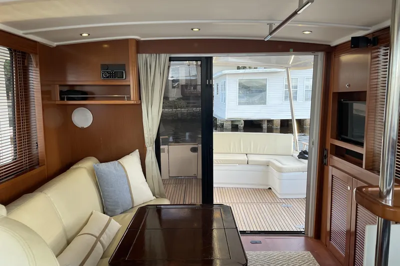 Slide: The Image of Interior of 2013 Beneteau Swift Trawler 44, featuring elegant wood and cream upholstery. - 21