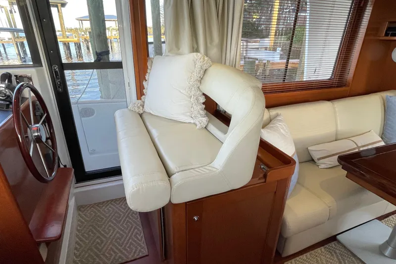 Slide: The Image of Interior of 2013 Beneteau Swift Trawler 44 with helm, seating, and wooden accents. - 23