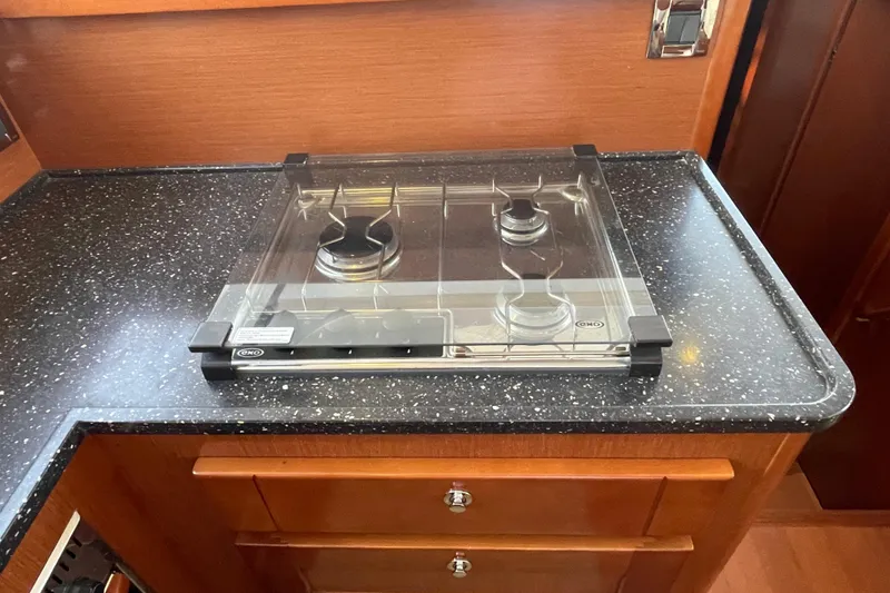 Slide: The Image of 2013 Beneteau Swift Trawler 44 kitchen with a two-burner stove and sleek countertop. - 26