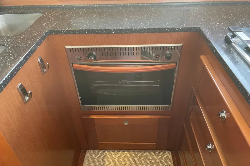 Slide: The Image of Galley kitchen in 2013 Beneteau Swift Trawler 44 with built-in oven and wood cabinetry. - 27
