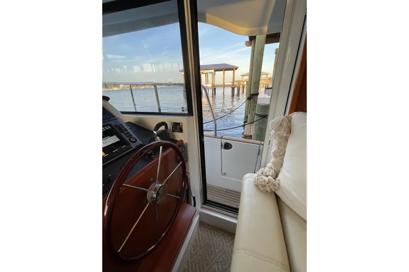 Slide: The Image of Interior view of 2013 Beneteau Swift Trawler 44, showcasing helm and waterfront scenery. - 28