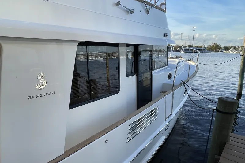 Slide: The Image of 2013 Beneteau Swift Trawler 44 docked, showcasing sleek design and spacious deck. - 3