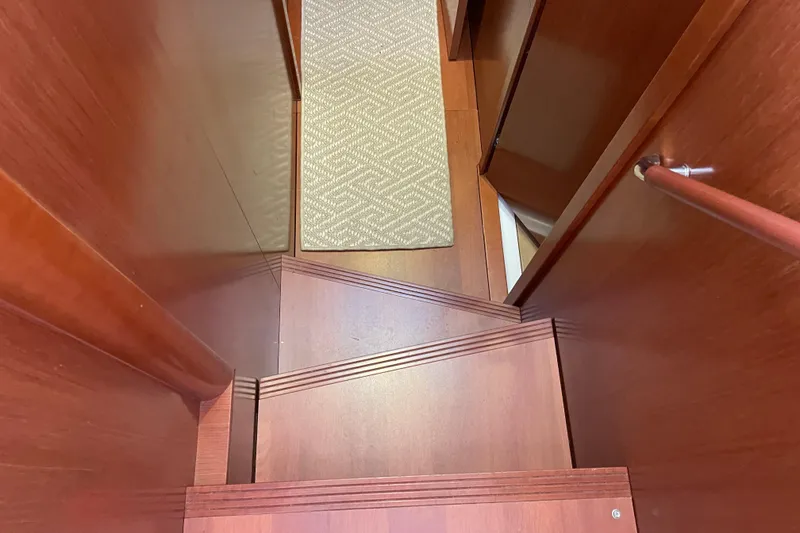 Slide: The Image of Wooden staircase inside 2013 Beneteau Swift Trawler 44, featuring a carpeted landing. - 32