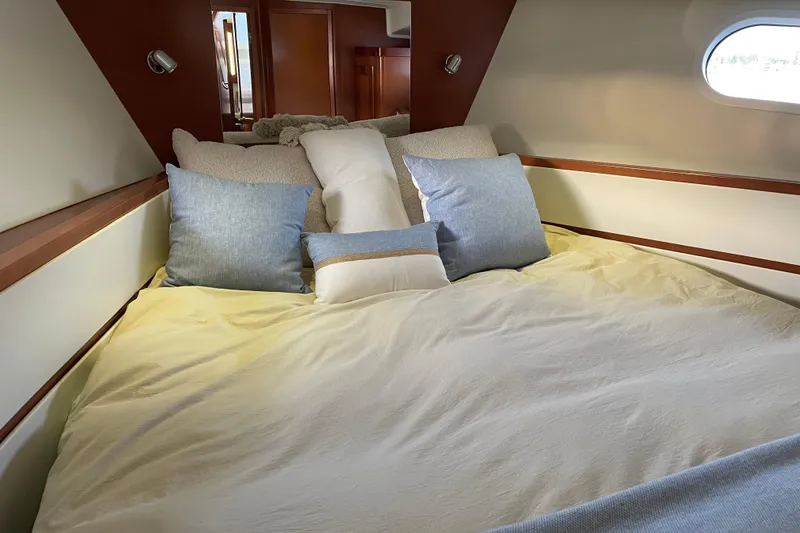 Slide: The Image of Cozy bedroom interior of 2013 Beneteau Swift Trawler 44 with plush pillows and natural light. - 37