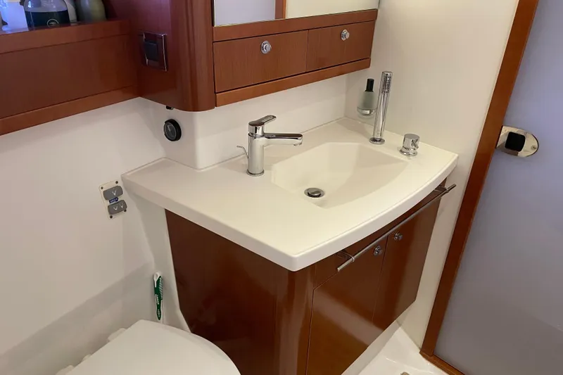 Slide: The Image of Bathroom sink area in 2013 Beneteau Swift Trawler 44, featuring modern fixtures and wooden cabinetry. - 40