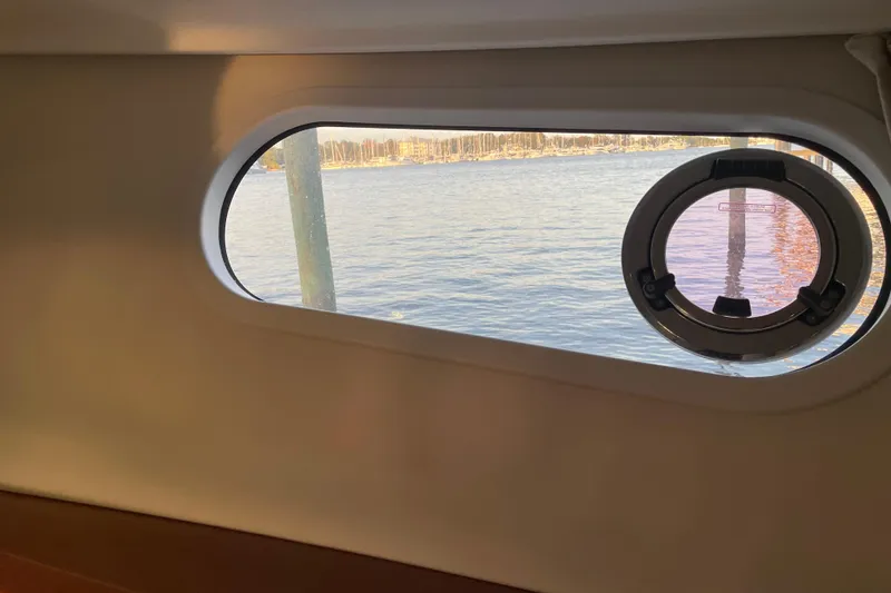 Slide: The Image of Porthole view from 2013 Beneteau Swift Trawler 44, overlooking calm waters and distant shoreline. - 42