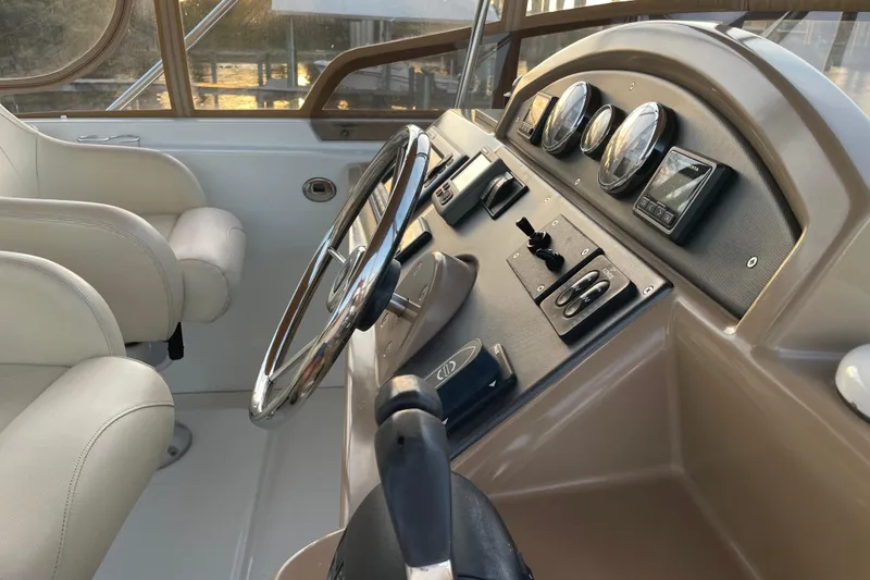 Slide: The Image of Helm of 2013 Beneteau Swift Trawler 44 with steering wheel and control panel. - 52