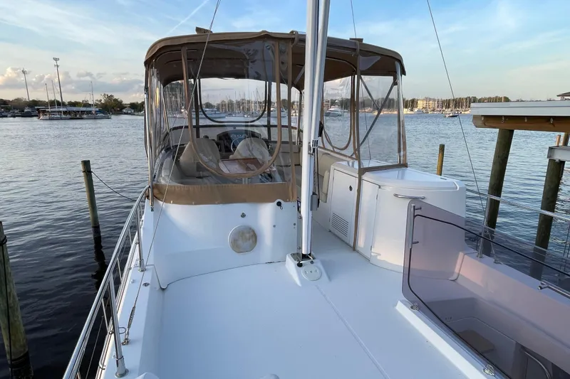 Slide: The Image of 2013 Beneteau Swift Trawler 44 docked, featuring spacious deck and enclosed helm area. - 56