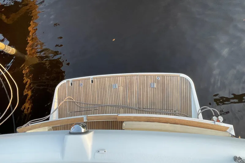 Slide: The Image of 2013 Beneteau Swift Trawler 44, wooden deck, docked on calm water. - 57