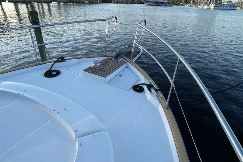 Slide: The Image of 2013 Beneteau Swift Trawler 44 bow view with railing and water backdrop. - 6