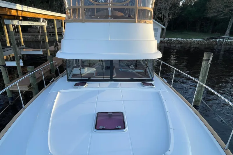 Slide: The Image of 2013 Beneteau Swift Trawler 44 docked, showcasing sleek design and spacious deck. - 8