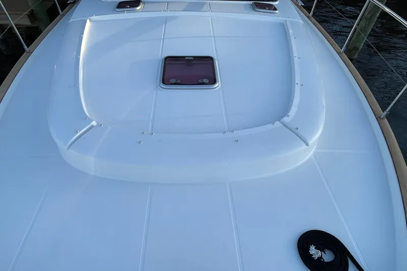 Slide: The Image of 2013 Beneteau Swift Trawler 44 deck with hatch and railing, docked by water. - 9