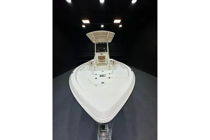 Slide: The Image of 2023 NauticStar 215 XTS boat in showroom, front view, under bright lighting. - 2
