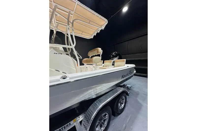 Slide: The Image of 2023 NauticStar 215 XTS boat on trailer in showroom, side view. - 4