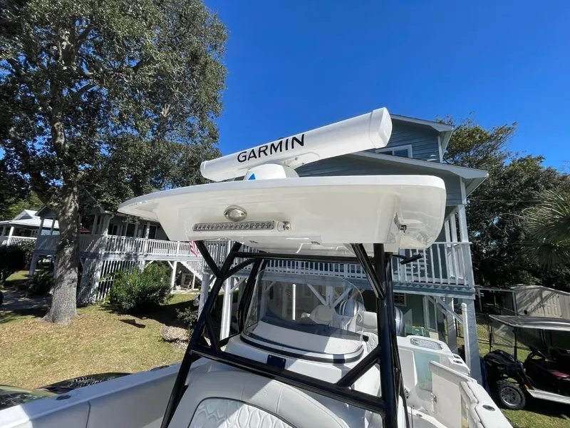 Slide: The Image of 2024 Sea Fox 288 Commander boat with Garmin radar, parked near a house under clear blue sky. - 20