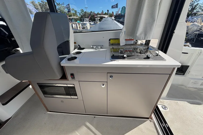 Slide: The Image of Interior of 2026 Beneteau Antares 9 V2 featuring a compact kitchen with stove and microwave. - 7