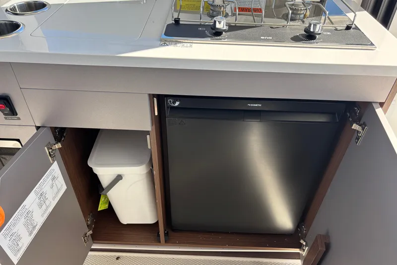 Slide: The Image of 2026 Beneteau Antares 9 V2 kitchen with stove, fridge, and storage cabinets. - 8