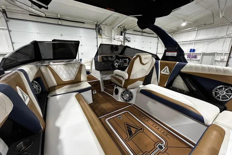 Slide: The Image of 2015 Tigé ASR boat interior with luxurious seating and modern dashboard in a garage setting. - 7