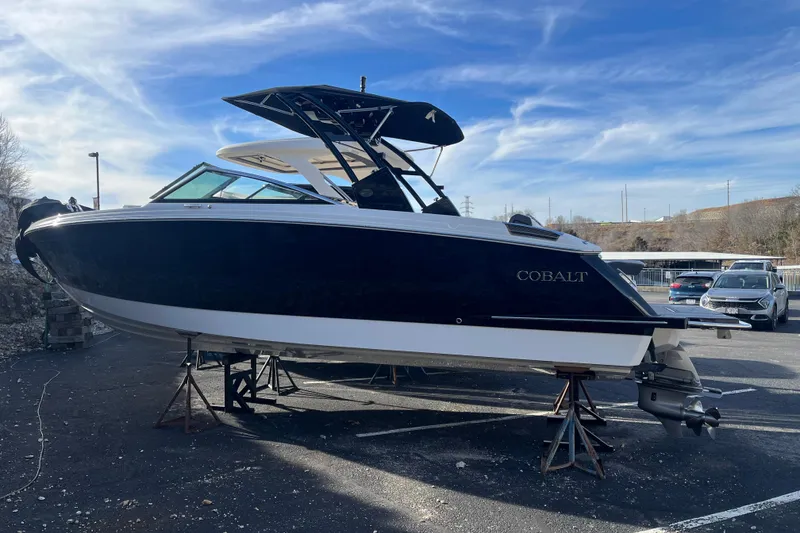 The Image of 2022 Cobalt R8 boat on stands in a parking lot under a clear blue sky. - 0