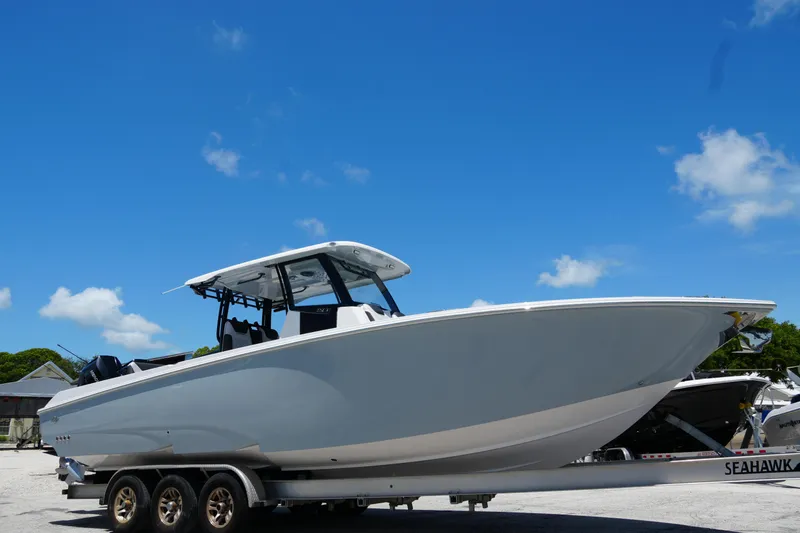 Slide: The Image of 2025 Fountain 32 NX Sportfish boat on trailer under clear blue sky. - 2