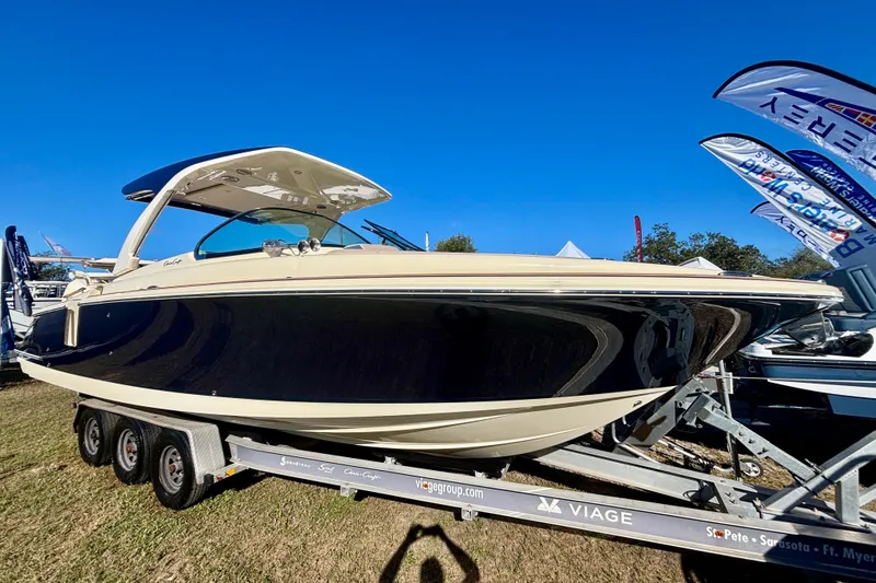 Slide: The Image of 2026 Chris-Craft Launch 31 GT boat on trailer, displayed outdoors under clear blue sky. - 2