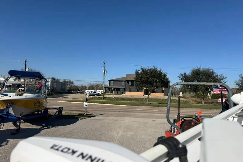 Slide: The Image of 2015 NauticStar 1910 NauticBay boat on trailer in sunny outdoor setting. - 10