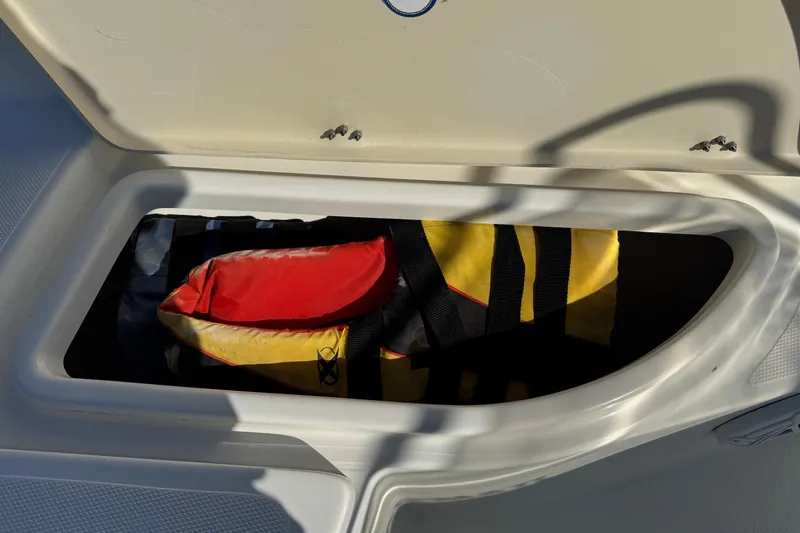 Slide: The Image of Storage compartment on 2015 NauticStar 1910 NauticBay boat with life jackets inside. - 12