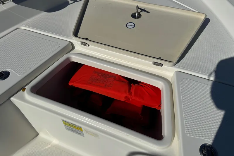 Slide: The Image of 2015 NauticStar 1910 NauticBay boat storage compartment with red life jacket inside. - 13