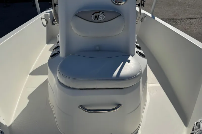 Slide: The Image of 2015 NauticStar 1910 NauticBay boat interior with cushioned seating and steering console. - 14