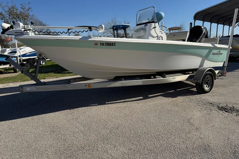 Slide: The Image of 2015 NauticStar 1910 NauticBay boat on trailer, parked outdoors. - 17