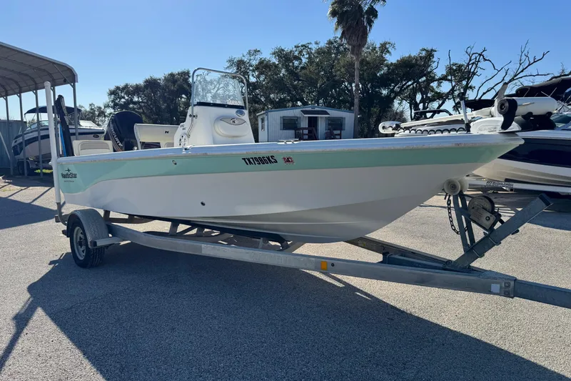 Slide: The Image of 2015 NauticStar 1910 NauticBay boat on trailer in sunny outdoor setting. - 19