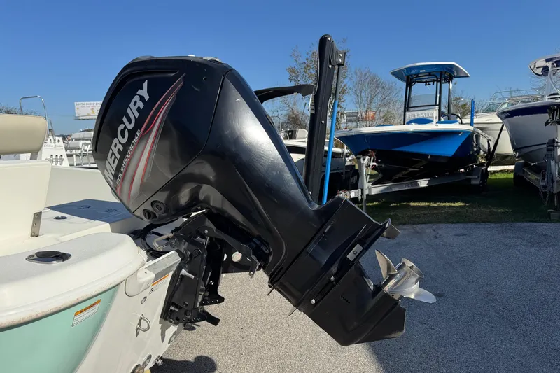 Slide: The Image of 2015 NauticStar 1910 NauticBay boat with Mercury outboard motor, parked outdoors. - 3