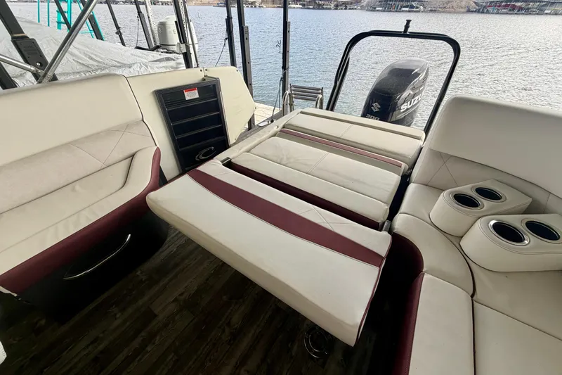 Slide: The Image of 2019 Crest Continental 250 SLS boat interior with white and maroon seating, cup holders, and lake view. - 13
