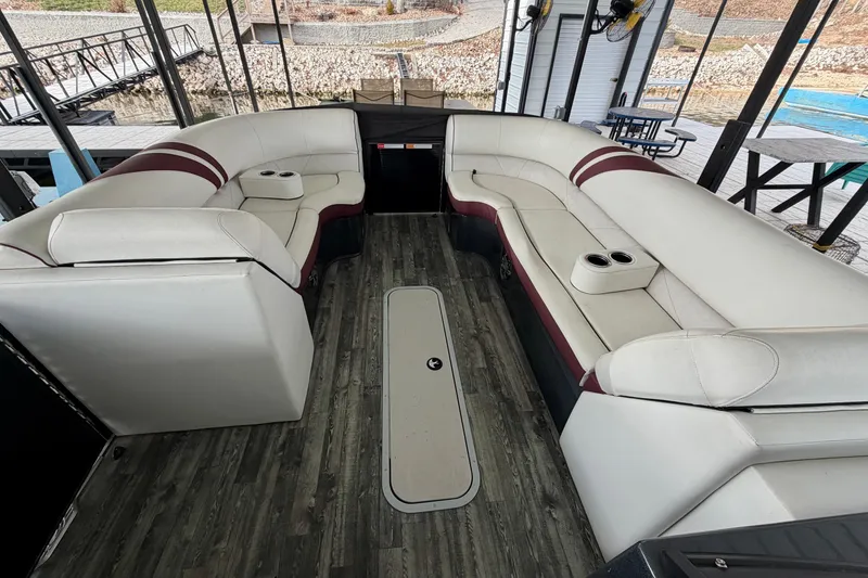 Slide: The Image of 2019 Crest Continental 250 SLS boat interior with white and maroon seating, docked at marina. - 32