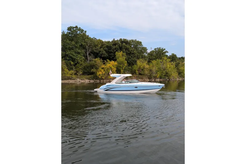Slide: The Image of 2025 Formula 310 Bowrider I/O cruising on a serene lake with lush greenery. - 11