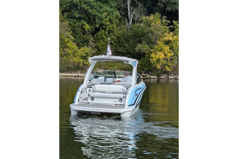 Slide: The Image of 2025 Formula 310 Bowrider I/O cruising on a serene lake with lush greenery. - 3