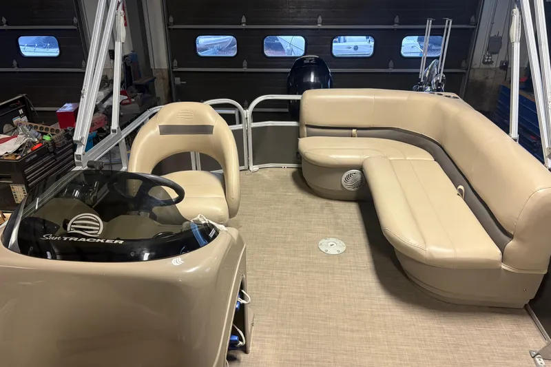 Slide: The Image of 2020 Sun Tracker Party Barge 18 DLX interior with beige seating and steering console. - 7