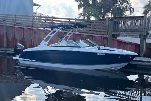 Slide: The Image of 2021 Cobalt R6 Outboard boat docked by wooden pier, reflecting on calm water. - 1
