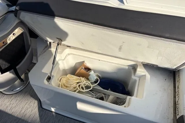 Slide: The Image of Open storage compartment on 2021 Cobalt R6 Outboard boat with ropes and accessories. - 29