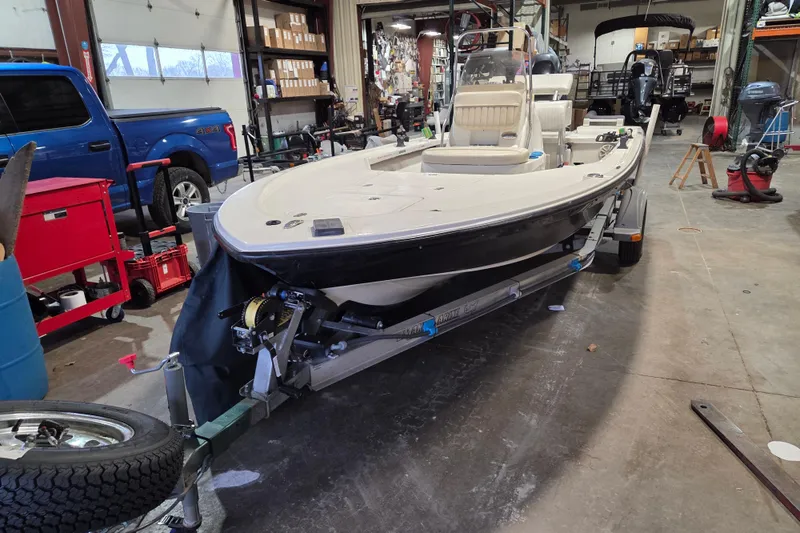 Slide: The Image of 2010 Mako 18 LTS boat on trailer in a workshop setting. - 2