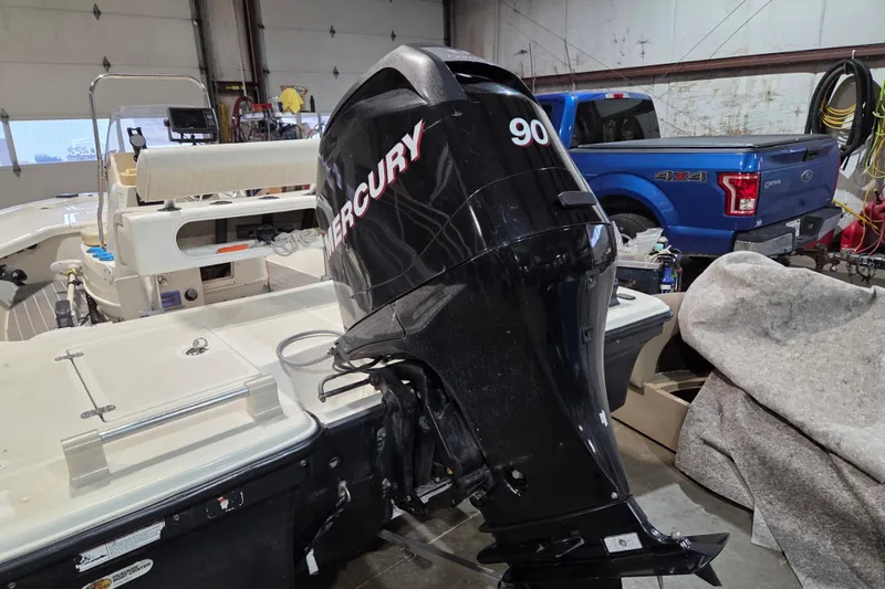 Slide: The Image of 2010 Mako 18 LTS boat with Mercury 90 outboard motor in a garage. - 4